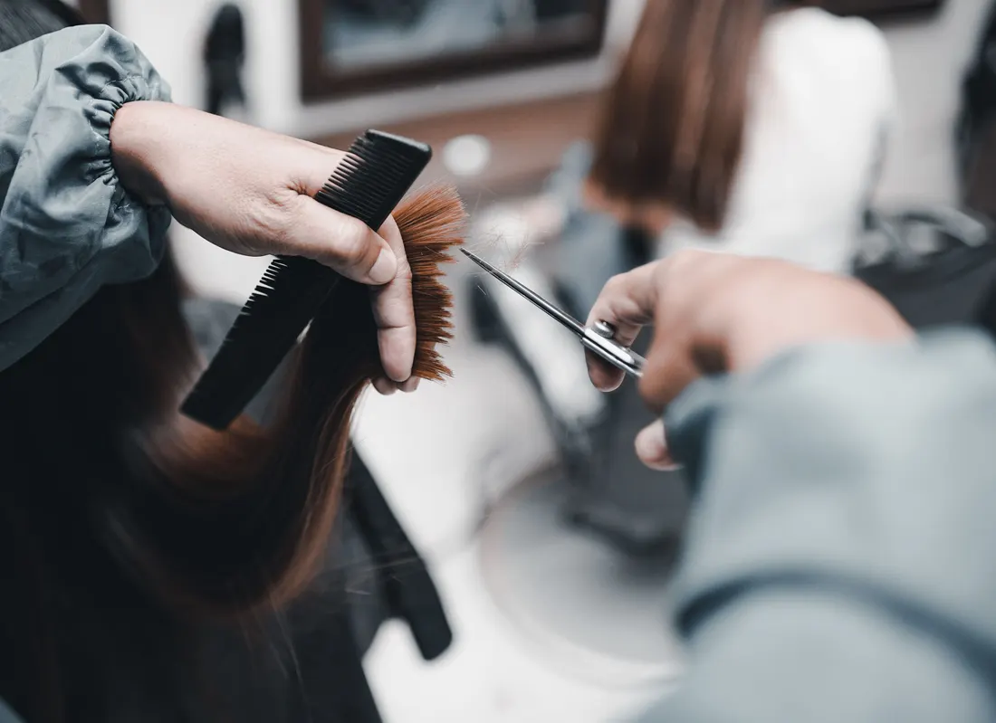 Illustrative stock photograph of a stylist’s hands shaping a haircut